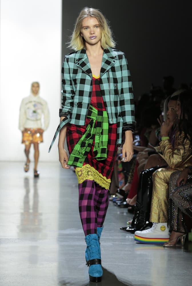 Model wearing colorful plaid outfit.